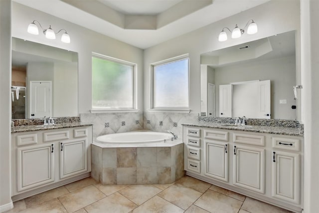 22907 Caverly Ln, Tomball, TX 77375 - full bathroom featuring a tray ceiling, two vanities, a garden tub, and tile patterned flooring
