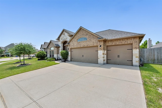 22907 Caverly Ln, Tomball, TX 77375 - french provincial home with an attached garage, brick siding, driveway, a shingled roof, and stone siding