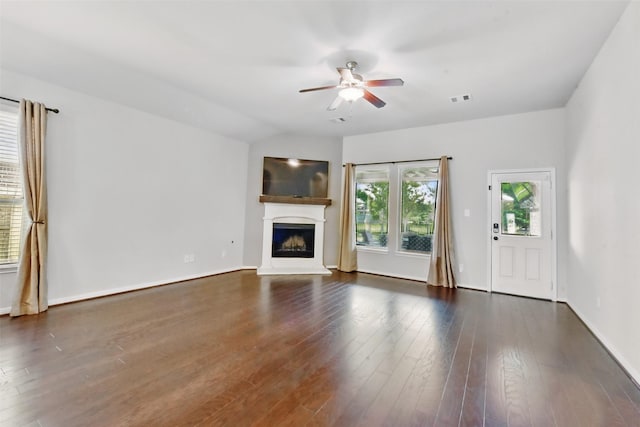 22907 Caverly Ln, Tomball, TX 77375 - unfurnished living room with ceiling fan, a fireplace with raised hearth, dark wood finished floors, and baseboards