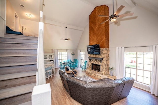 1981 County Road 291, Sargent, TX 77414 - living room with ceiling fan, high vaulted ceiling, stairs, wood finished floors, and a stone fireplace