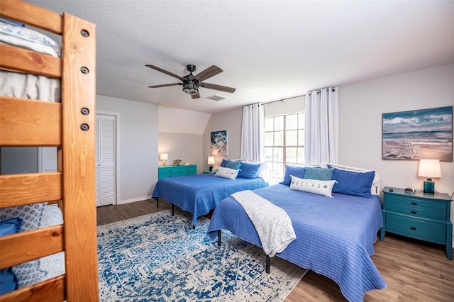 1981 County Road 291, Sargent, TX 77414 - bedroom with wood finished floors, a ceiling fan, a textured ceiling, and baseboards