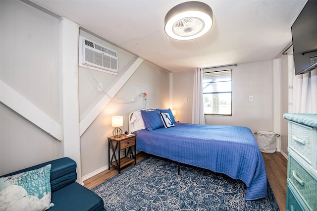 1981 County Road 291, Sargent, TX 77414 - bedroom featuring wood finished floors, a wall mounted AC, and baseboards