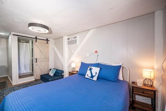 1981 County Road 291, Sargent, TX 77414 - bedroom featuring a barn door and a wall mounted air conditioner