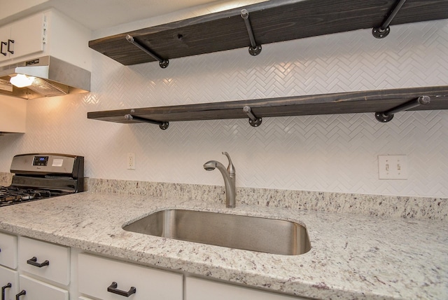 3206 Windchase Blvd Unit 471, Houston, TX 77082 - kitchen with open shelves, a sink, tasteful backsplash, white cabinetry, and stainless steel range with gas cooktop