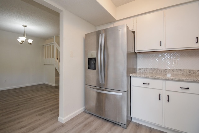 3206 Windchase Blvd Unit 471, Houston, TX 77082 - kitchen with stainless steel refrigerator with ice dispenser, light wood-type flooring, decorative backsplash, a chandelier, and baseboards