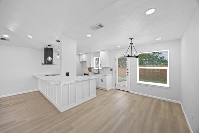 16631 Quiet Quail Dr, Missouri City, TX 77489 - kitchen featuring light wood-style floors, white cabinetry, a peninsula, baseboards, and recessed lighting
