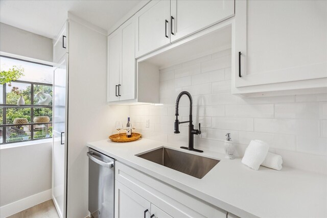 2829 Timmons Ln Unit 174, Houston, TX 77027 - kitchen featuring a sink, stainless steel dishwasher, decorative backsplash, light countertops, and white cabinetry