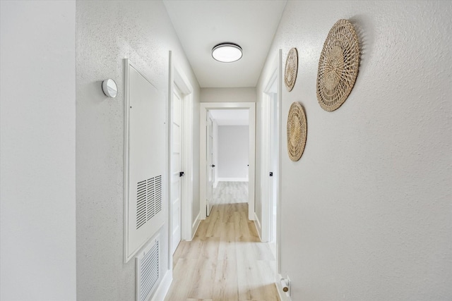 2829 Timmons Ln Unit 174, Houston, TX 77027 - hall featuring light wood finished floors, baseboards, and a textured wall