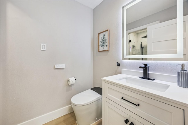 2829 Timmons Ln Unit 174, Houston, TX 77027 - bathroom featuring vanity, wood finished floors, toilet, a shower with door, and baseboards