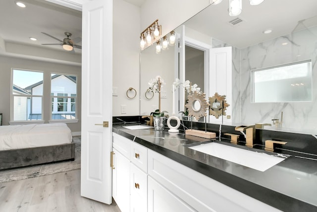 6551 Sealey St, Houston, TX 77091 - ensuite bathroom with wood finished floors, double vanity, a ceiling fan, and recessed lighting
