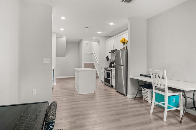8534 Woodlyn Rd, Houston, TX 77028 - kitchen with appliances with stainless steel finishes, white cabinetry, a center island, light wood-type flooring, and recessed lighting