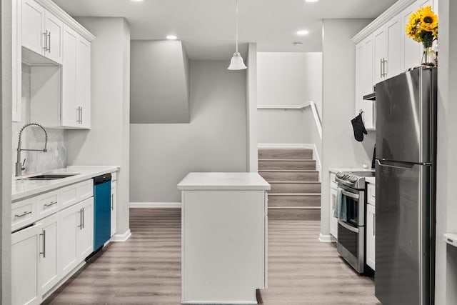 8534 Woodlyn Rd, Houston, TX 77028 - kitchen with stainless steel appliances, a kitchen island, light countertops, light wood-type flooring, and recessed lighting