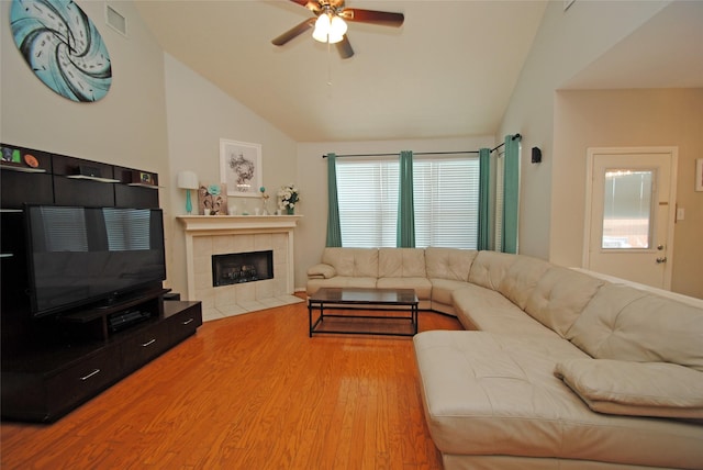 9723 Therrell Dr, Houston, TX 77064 - living area with vaulted ceiling, a ceiling fan, plenty of natural light, wood finished floors, and a tile fireplace