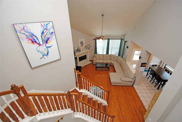 9723 Therrell Dr, Houston, TX 77064 - staircase featuring lofted ceiling, wood finished floors, a premium fireplace, and a ceiling fan