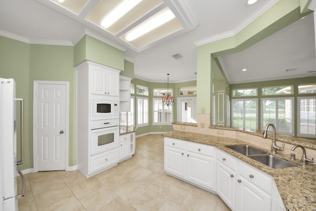 22127 Glen Arden Ln, Katy, TX 77450 - kitchen featuring white appliances, a sink, ornamental molding, light stone counters, and white cabinets