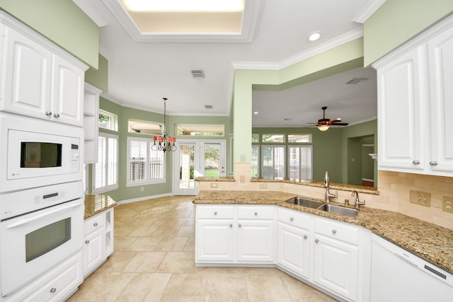22127 Glen Arden Ln, Katy, TX 77450 - kitchen featuring white appliances, a sink, ornamental molding, light stone counters, and decorative backsplash
