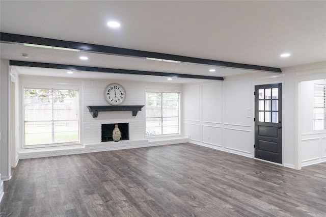 17426 Pinewood Forest Dr, Spring, TX 77379 - unfurnished living room with beamed ceiling, a decorative wall, wood finished floors, a brick fireplace, and recessed lighting