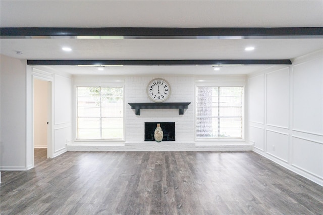 17426 Pinewood Forest Dr, Spring, TX 77379 - unfurnished living room with beam ceiling, a brick fireplace, wood finished floors, baseboards, and a decorative wall