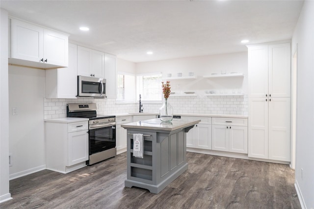 17426 Pinewood Forest Dr, Spring, TX 77379 - kitchen featuring stainless steel appliances, open shelves, dark wood-style floors, a sink, and white cabinetry