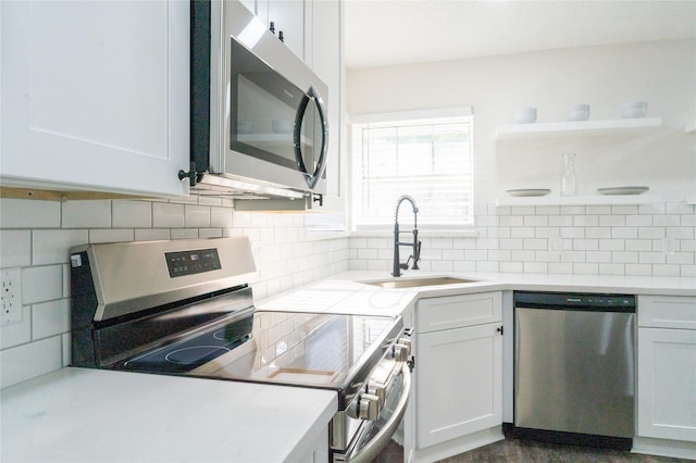 17426 Pinewood Forest Dr, Spring, TX 77379 - kitchen featuring appliances with stainless steel finishes, a sink, open shelves, and decorative backsplash