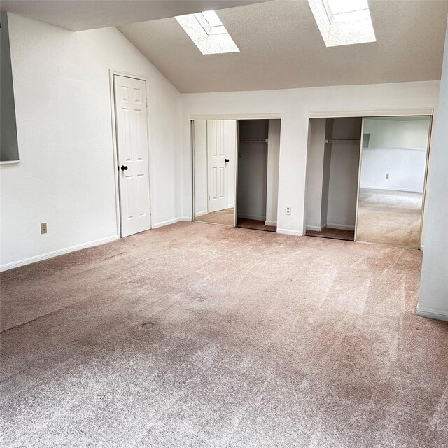 16800 Sugar Pine Dr Unit C21, Houston, TX 77090 - unfurnished bedroom featuring a skylight, multiple closets, carpet floors, vaulted ceiling, and baseboards