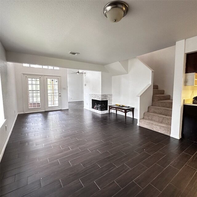 16800 Sugar Pine Dr Unit C21, Houston, TX 77090 - living room with wood finish floors, a multi sided fireplace, stairway, baseboards, and a textured ceiling