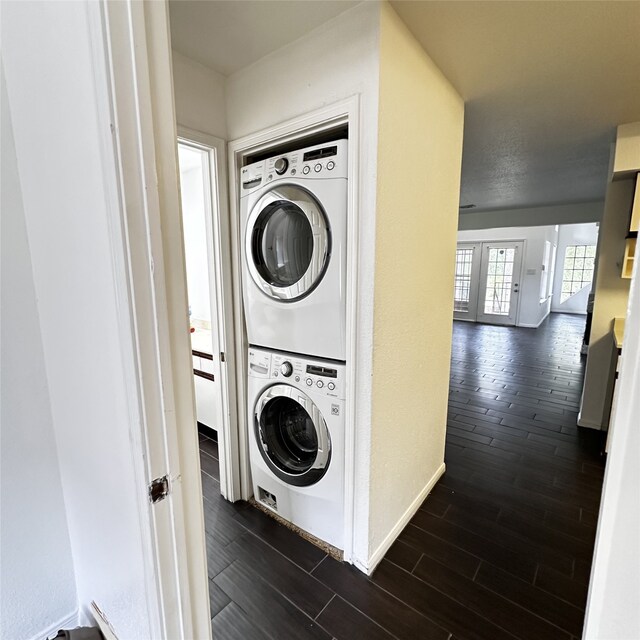 16800 Sugar Pine Dr Unit C21, Houston, TX 77090 - laundry area with stacked washer and clothes dryer, dark wood-style floors, and baseboards