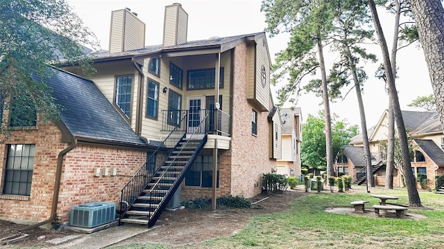16800 Sugar Pine Dr Unit C21, Houston, TX 77090 - back of property featuring stairs, brick siding, central air condition unit, and a chimney