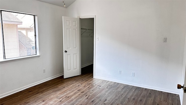 16800 Sugar Pine Dr Unit C21, Houston, TX 77090 - unfurnished bedroom featuring a walk in closet, wood finished floors, baseboards, a closet, and lofted ceiling