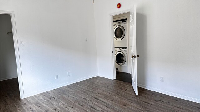 16800 Sugar Pine Dr Unit C21, Houston, TX 77090 - laundry area featuring stacked washer / dryer, dark wood-type flooring, and baseboards