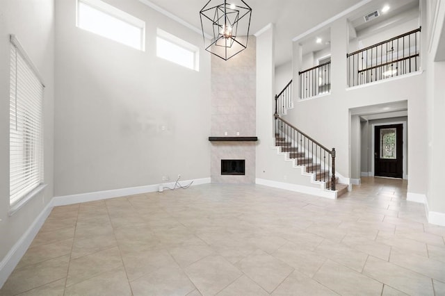 28911 Copper Break Ct, Katy, TX 77494 - foyer entrance with a high ceiling, stairs, a chandelier, a tile fireplace, and crown molding