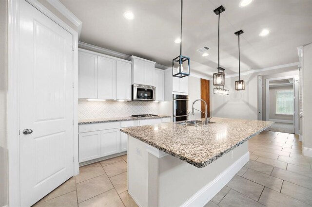 28911 Copper Break Ct, Katy, TX 77494 - kitchen with stainless steel appliances, tasteful backsplash, light tile patterned flooring, a sink, and a kitchen island with sink
