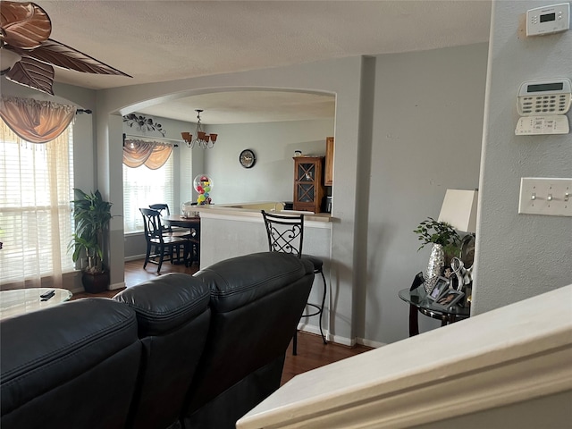 20347 Hunterclif Ln, Katy, TX 77449 - living area with arched walkways, baseboards, dark wood-style flooring, a chandelier, and a ceiling fan