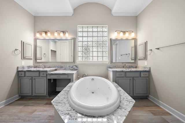 4021 Windsor Chase Dr, Spring, TX 77386 - bathroom featuring crown molding, baseboards, a tub with jets, two vanities, and wood finished floors