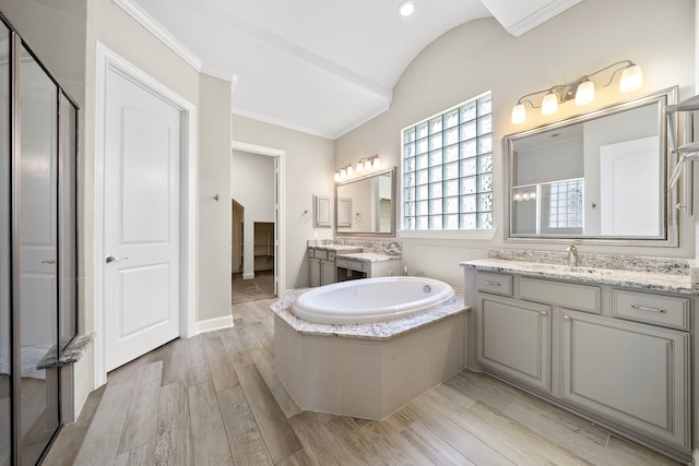 4021 Windsor Chase Dr, Spring, TX 77386 - bathroom featuring vaulted ceiling, wood finished floors, a garden tub, a stall shower, and ornamental molding