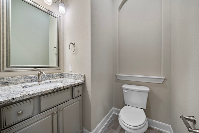4021 Windsor Chase Dr, Spring, TX 77386 - half bathroom with baseboards, vanity, toilet, and wood finished floors