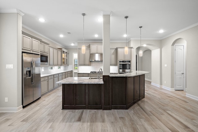 4021 Windsor Chase Dr, Spring, TX 77386 - kitchen featuring stainless steel appliances, under cabinet range hood, a sink, arched walkways, and light wood finished floors