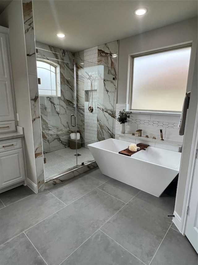 300 Camden Hills Dr, Montgomery, TX 77356 - bathroom featuring a freestanding bath, a marble finish shower, recessed lighting, tile walls, and tile patterned flooring