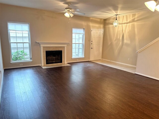 2924 Holly Hall St Unit 2924, Houston, TX 77054 - unfurnished living room with wood finished floors, baseboards, a tiled fireplace, and a ceiling fan