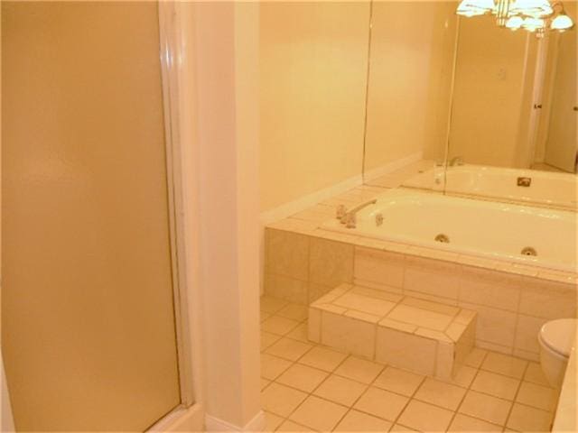 2924 Holly Hall St Unit 2924, Houston, TX 77054 - full bathroom with a tub with jets, tile patterned flooring, a chandelier, and toilet