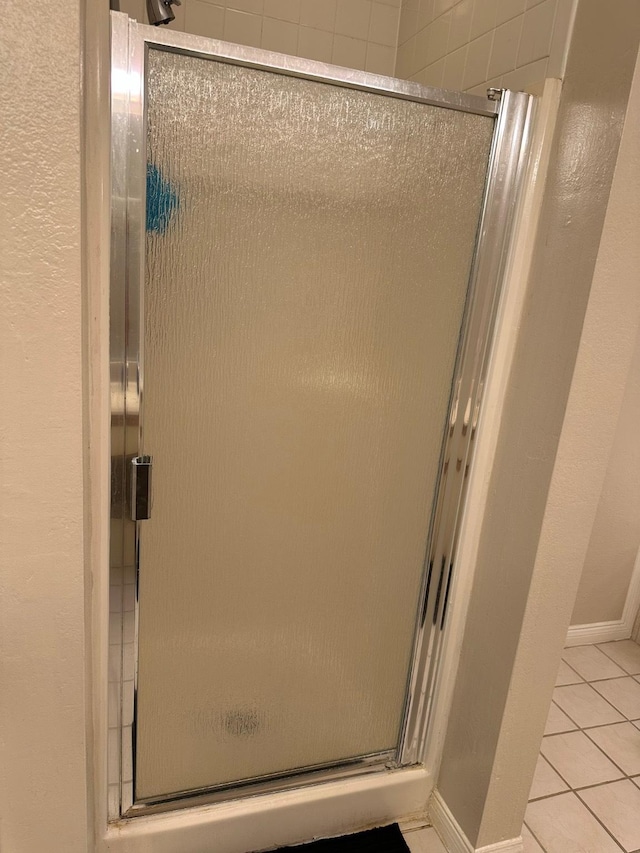 2924 Holly Hall St Unit 2924, Houston, TX 77054 - full bathroom featuring a shower stall, tile patterned flooring, baseboards, and a textured wall