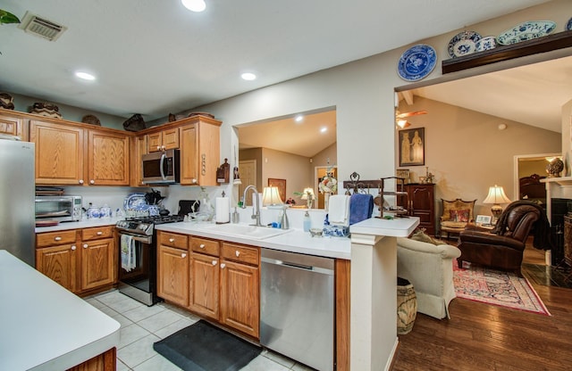 5109 Glenview Ct, La Porte, TX 77571 - kitchen featuring stainless steel appliances, a sink, vaulted ceiling, light countertops, and recessed lighting
