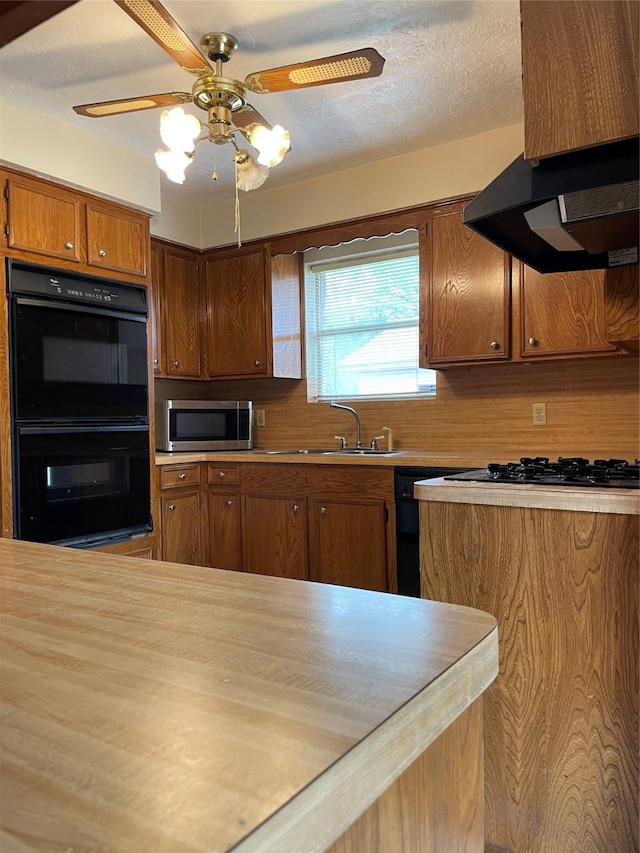 1501 N Park Side Dr, Deer Park, TX 77536 - kitchen featuring black appliances, light countertops, brown cabinetry, ventilation hood, and a sink