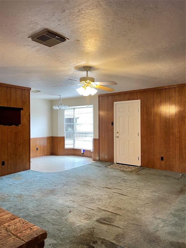 1501 N Park Side Dr, Deer Park, TX 77536 - unfurnished living room with wooden walls, carpet floors, wainscoting, a ceiling fan, and a textured ceiling