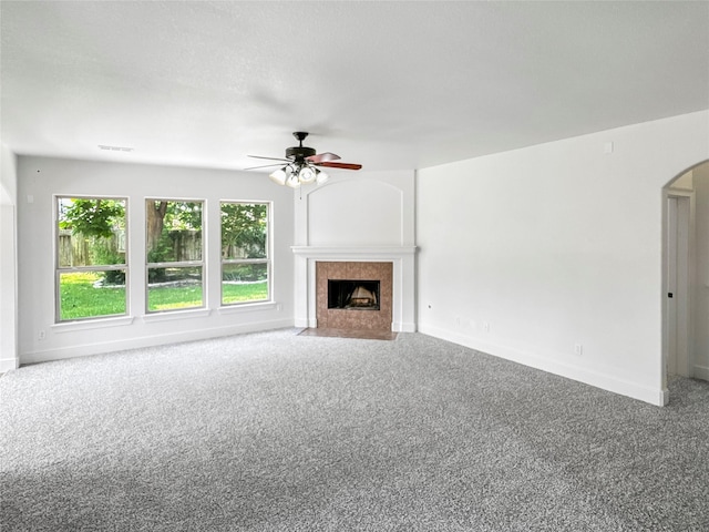 16019 Rustlers Trail Ln, Cypress, TX 77429 - unfurnished living room featuring arched walkways, a ceiling fan, carpet, a fireplace, and baseboards