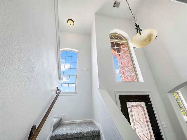 16019 Rustlers Trail Ln, Cypress, TX 77429 - carpeted entrance foyer featuring plenty of natural light, baseboards, a textured wall, a high ceiling, and stairs