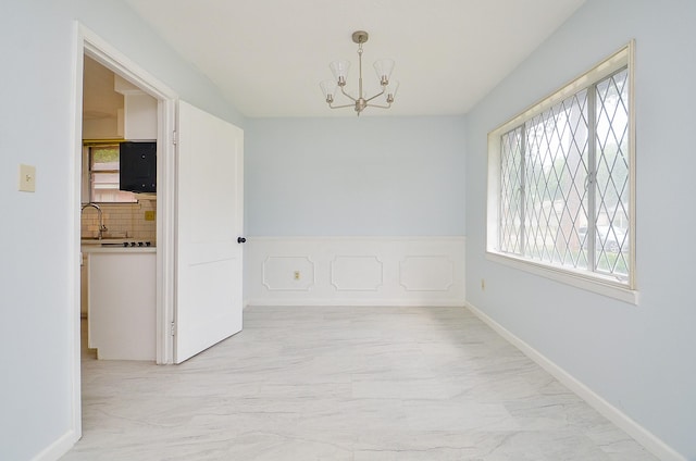 10947 Vanderford Dr, Houston, TX 77099 - unfurnished dining area with a chandelier, light marble finish flooring, and a sink