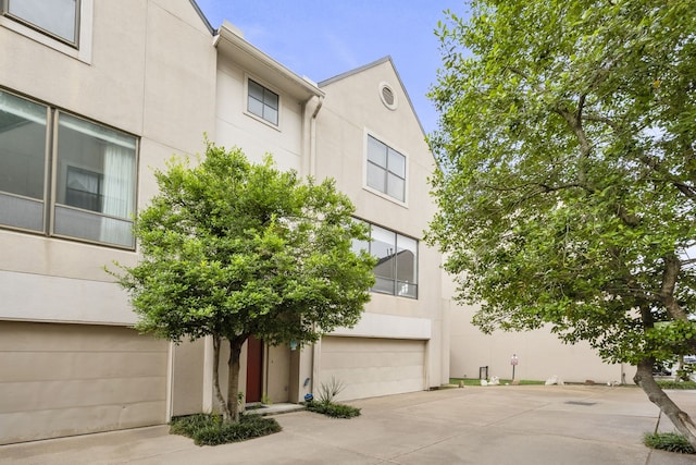 939 Colorado St Unit 22, Houston, TX 77007 - view of front of house featuring stucco siding, a garage, and driveway