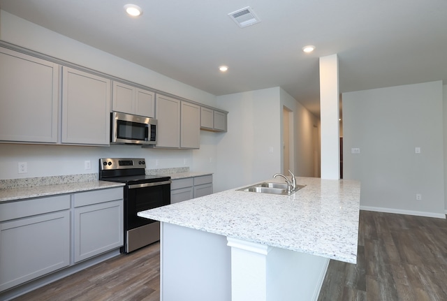 26449 Lakeshore Dr, Hempstead, TX 77445 - kitchen featuring stainless steel appliances, a sink, gray cabinetry, dark wood-style flooring, and a kitchen island with sink