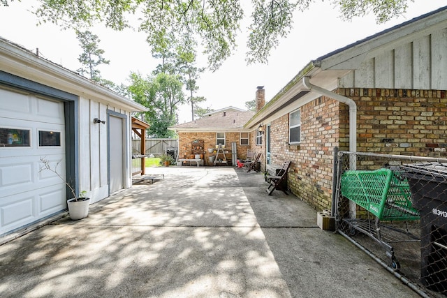 5423 Willow Creek Way, Houston, TX 77017 - view of side of property featuring board and batten siding, brick siding, a chimney, and a patio
